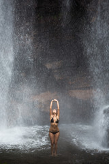 Fototapeta na wymiar Beautiful woman in bikini and waterfall.