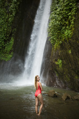 Fototapeta na wymiar Beautiful woman in red bikini and waterfall.