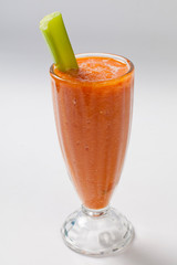 cold carrot smoothie with celery in the glass
