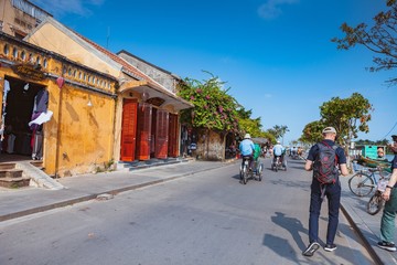 HOI AN, VIETNAM - MARCH 15, 2017: Group of people travel Hoian old town, ancient house, country heritage, city friendly with environment, walk, bicycle or pedicab on street, traveller visit at Vietnam