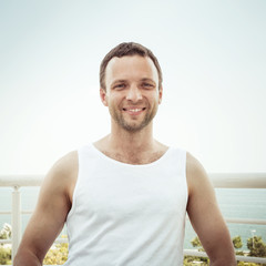 Fototapeta premium Young smiling European man in white shirt
