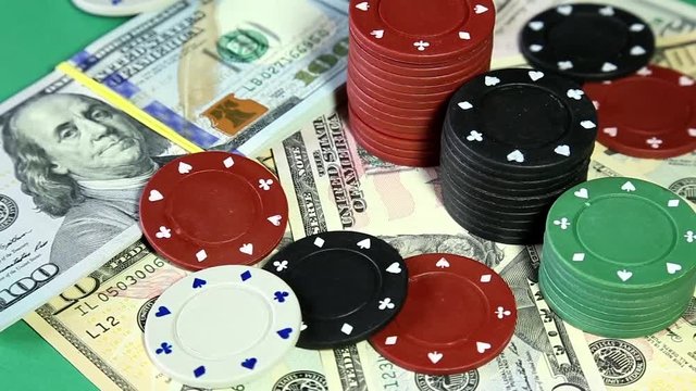 poker chips and dollars on rotating surface.