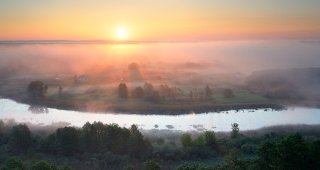 Summer landscape with a morning mist over the river