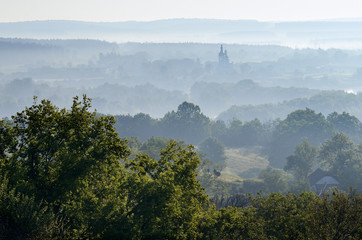 Summer landscape with mist over the village