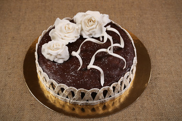 Chocolate cake decorated white fondant flowers. Bakery. Sweet food. Homemade cake.