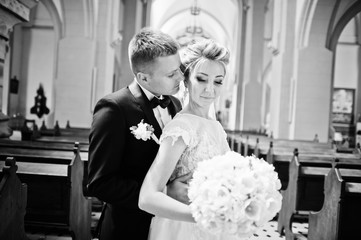 Photosession of stylish wedding couple on catholic church.