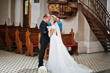 Photosession of stylish wedding couple on catholic church.