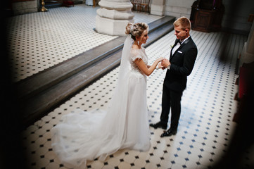 Fototapeta premium Photosession of stylish wedding couple on catholic church.
