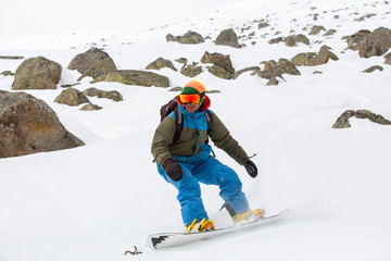 snowboarder snowboarding on fresh snow on ski slope on Sunny winter day in the ski resort in Georgia