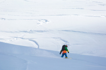 snowboarder snowboarding on fresh snow on ski slope on Sunny winter day in the ski resort in Georgia