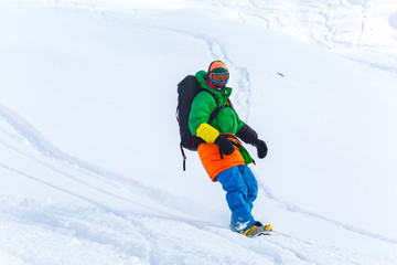 Fototapeta na wymiar snowboarder snowboarding on fresh snow on ski slope on Sunny winter day in the ski resort in Georgia