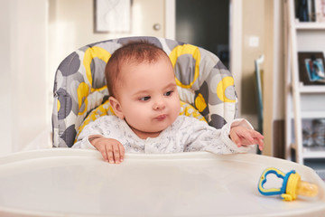 baby eating food on kitchen