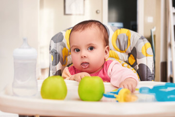 baby eating food on kitchen