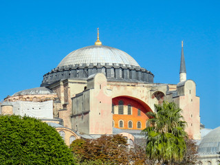 Fototapeta na wymiar The colourful Hagia Sofia against clear blue sky. It was formerly a christian church, but is now a mosque and a museum in Istanbul.
