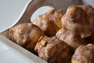 Closeup of Jerusalem artichokes in wooden container