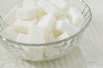 Closeup of cubes of white sugar in a crystal bowl