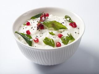 Curd rice served in a white bowl on white background