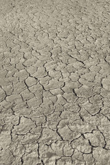 Top view of cracked and barren ground, clay desert texture.Color toned.