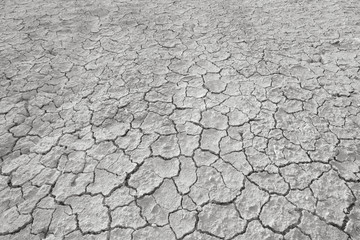 Top view of cracked and barren ground, clay desert texture.Color toned.