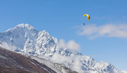Paraglider flying against the mountain Lhotse (8516 m) - Everest region, Nepal, Himalayas