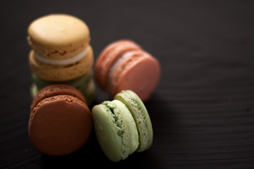 Delicious multicolored cake macaron or macaroon on black background