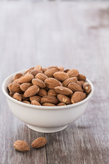 White Bowl of Almonds on Wood Background