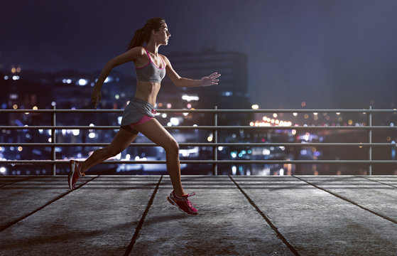 Läuferin joggt vor beleuchteter Stadt