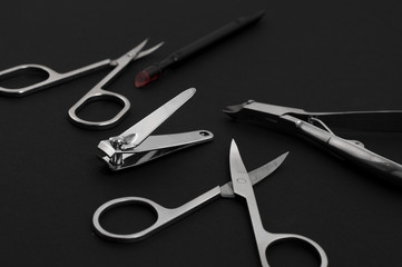 set of metallic manicure tools on a black background