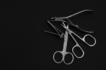 set of metallic manicure tools on a black background