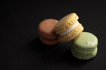 Delicious multicolored cake macaron or macaroon on black background