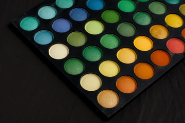 Palette of professional colorful eye shadows. Collection of multicolor eyeshadows. Makeup set background.