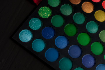 Palette of professional colorful eye shadows. Collection of multicolor eyeshadows. Makeup set background.