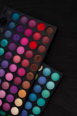 Palette of professional colorful eye shadows. Collection of multicolor eyeshadows. Makeup set background.