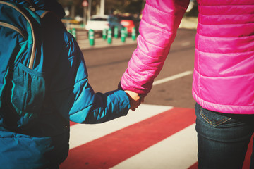 Mother holding hand of little son at crossroads