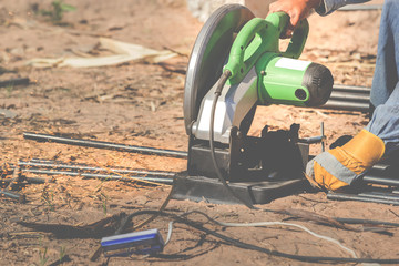 The electric iron cutter cut the iron on the ground.