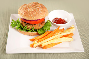 A back bean and couscous (vegan) hamburger with parsnip and sweet potato fries.