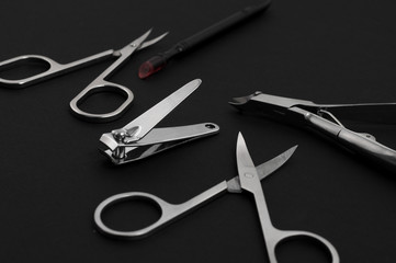 set of metallic manicure tools on a black background