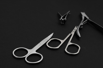 set of metallic manicure tools on a black background