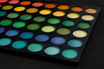 Palette of professional colorful eye shadows. Collection of multicolor eyeshadows. Makeup set background.