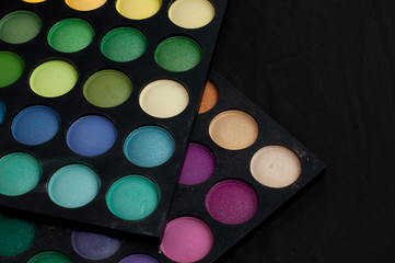 Palette of professional colorful eye shadows. Collection of multicolor eyeshadows. Makeup set background.