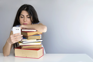 tired and sad  student  woman with books and phone in the hand