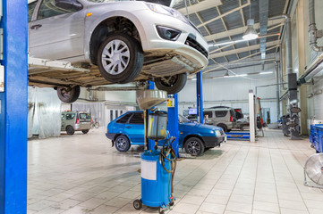 The car on the lift. Change engine oil and transmission inspection