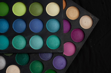 Palette of professional colorful eye shadows. Collection of multicolor eyeshadows. Makeup set background.