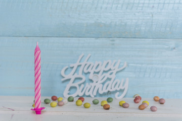 one pink  birthday candle isolated on a blue  wooden background