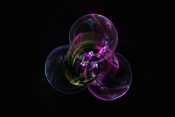 Abstract fractal bubbles in purples and pinks with reflections, on dark background