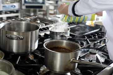 Chef in hotel or restaurant kitchen cooking
