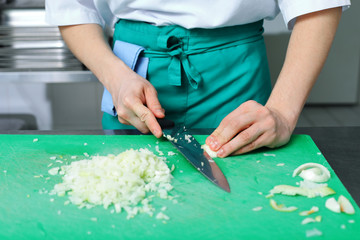 Cook is chopping onion
