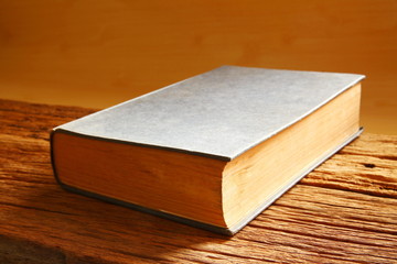 Old book put on the brown color hard wood represent the book background concept related idea.