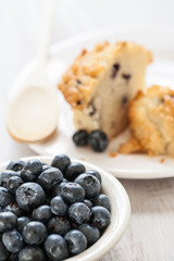 Bowl of Blueberries with Blueberry Muffin and Wooden Spoon