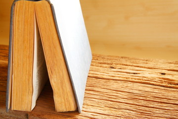 Old book put on the brown color hard wood represent the book background concept related idea.